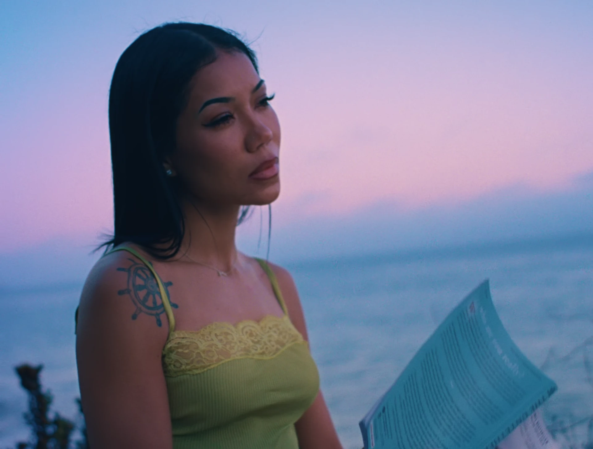 Jhene Aiko beside the ocean at sunset